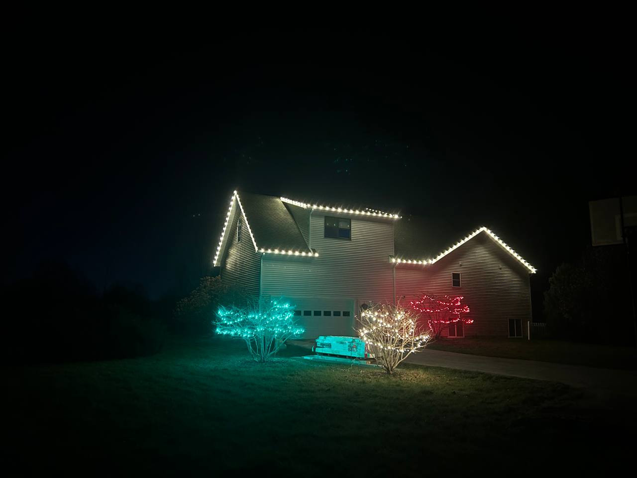 Warm white Christmas lights outlining a single-story home at night